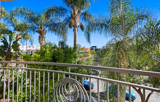 a balcony with a chair and palm trees