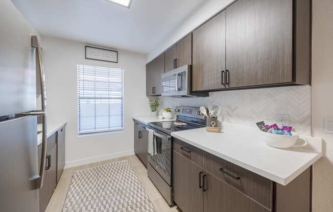 A kitchen with cabinets and stainless steel appliances