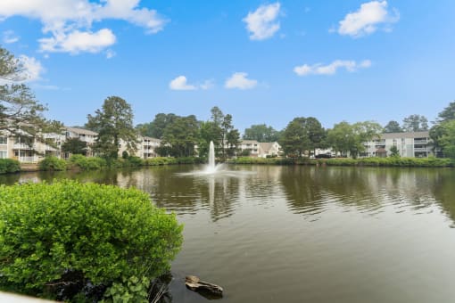 a fountain in the middle of a lake with apartment buildings in the background at Linkhorn Bay Apartments, Virginia Beach, VA, 23451