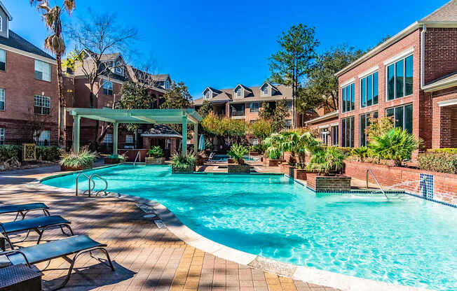 A large swimming pool surrounded by lounge chairs and trees.