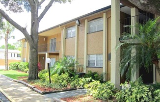 an apartment building with a sidewalk and trees