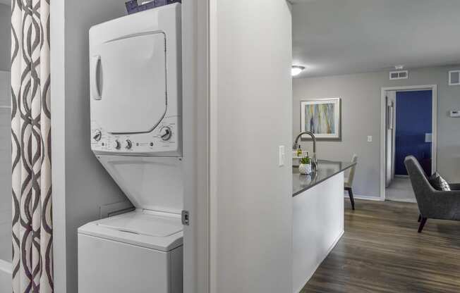 a white washer and dryer in a room next to a kitchen