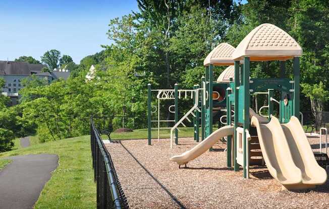 A playground with a green slide and a yellow slide.