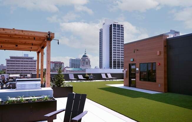 A wooden pergola is on a patio with a bench and a planter at The Pearl, Indiana