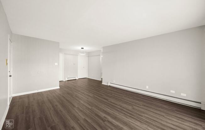 a living room with white walls and wood floors