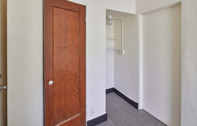 a room with a wooden door and a white wall at MILEPOST 5 Apartments, PORTLAND, OR