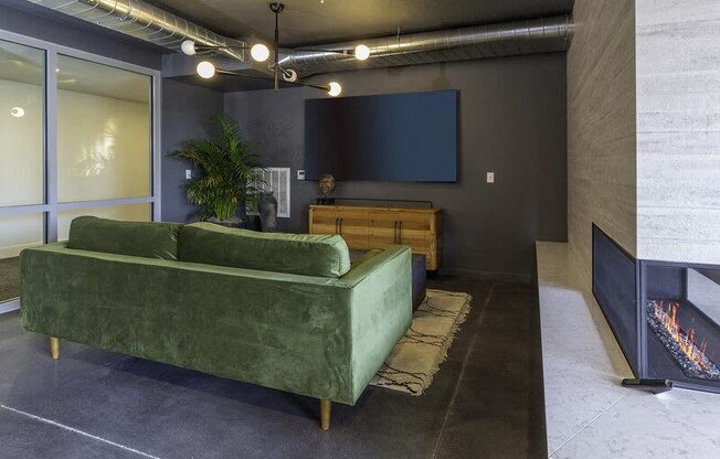 A living room with a green couch and a fireplace.