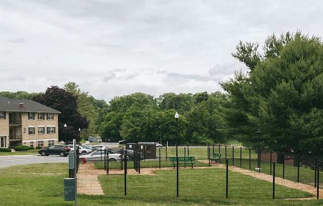 A park with a baseball field and apartment buildings in the background.