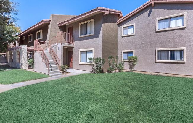 a house with a lawn in front of a brick building