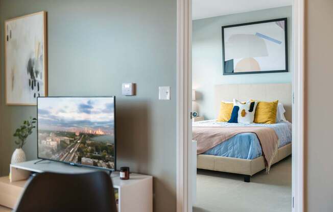 A television is on a stand in a bedroom.
