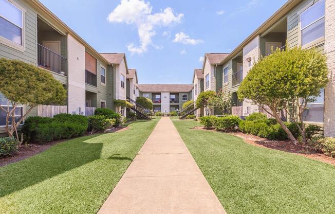 Central view of The Avenue apartment complex with spotless sidewalks and lush garden landscaping