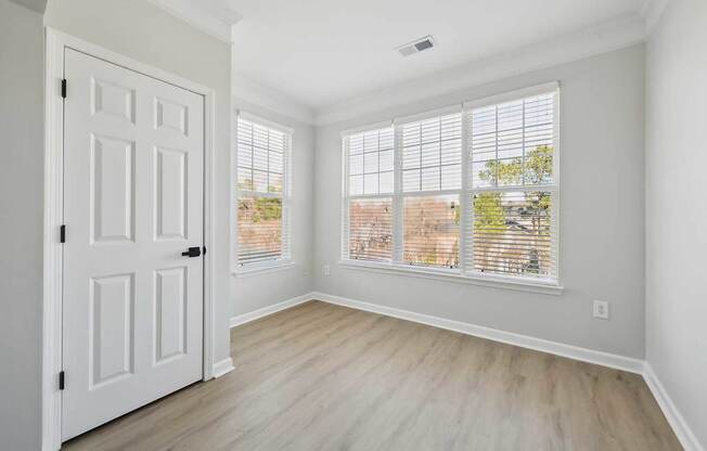 A room with a white door and a window with blinds.