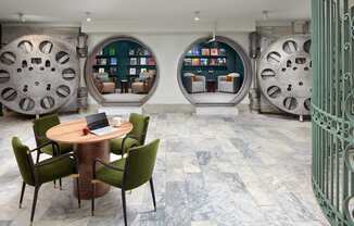 A room with a table and chairs in front of a wall with circular windows.