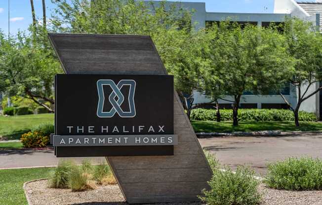 A sign for The Halifax Apartment Homes is displayed in front of a building.