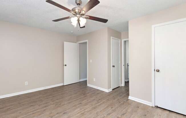 an empty living room with a ceiling fan