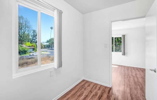 a living room with a large window and a wooden floor