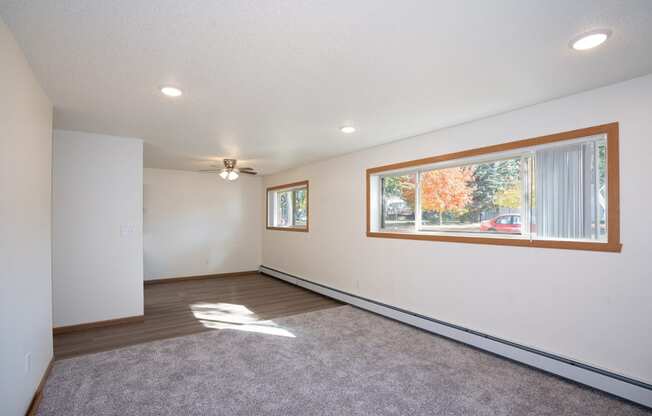 a living room with a large window and a carpet. Fargo, ND Country Club Apartments