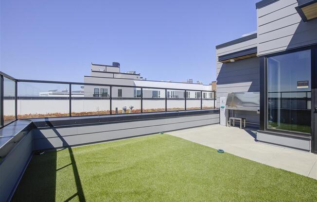 a roof terrace with a grassy area and a view of a body of water