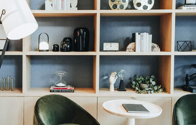 a living room with green chairs and a bookshelf at The Lively, Jersey City