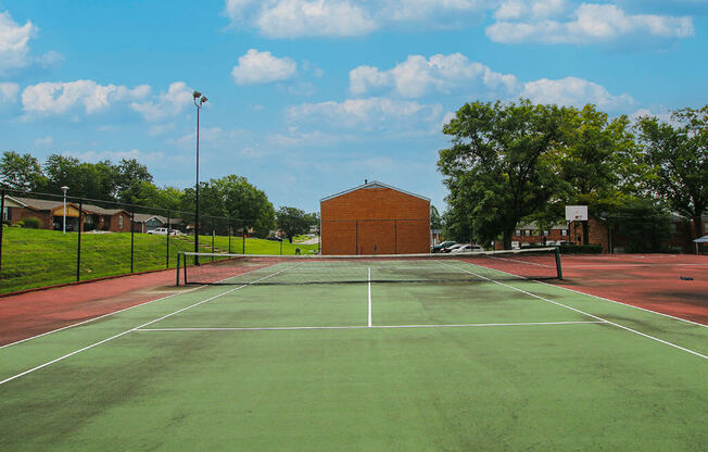 a tennis court with a brick building in the background