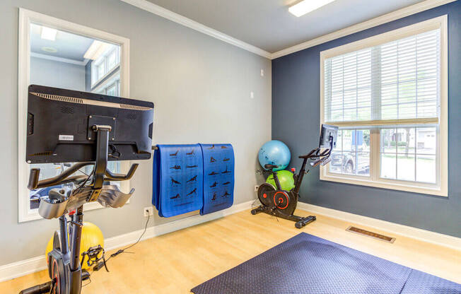 a home gym with exercise bikes and a tv