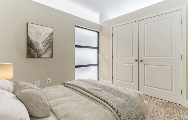 a bedroom with a large bed and a window