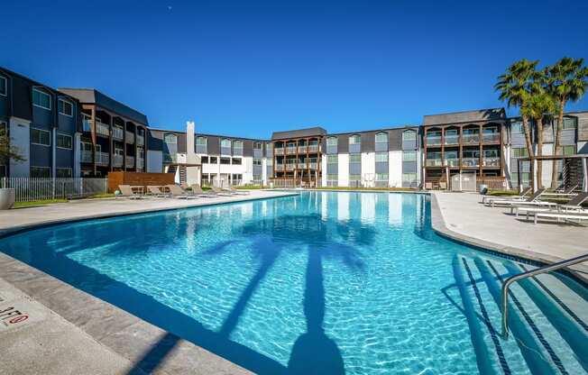 a large swimming pool with a building in the background