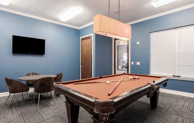 a games room with a pool table and a tv