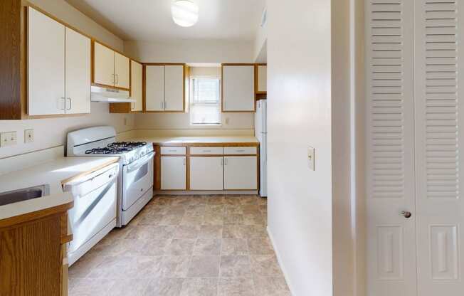end style kitchen with window and white appliances at Canal Club Apartments, Lansing, Michigan