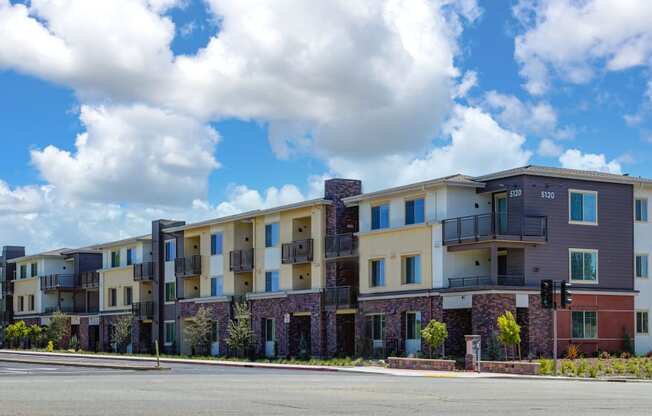 a picture of an apartment building with a cloudy sky in the background