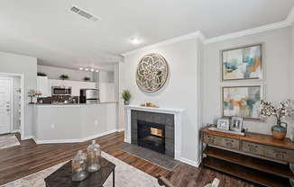 A living room with a fireplace and a large painting on the wall.