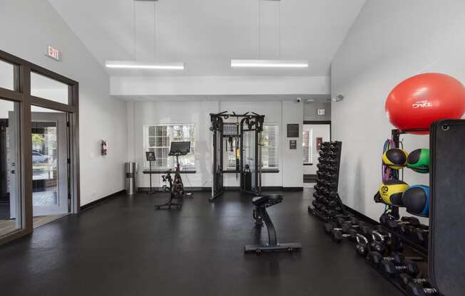 a workout room with weights and a large red ball on the floor