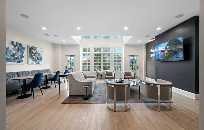 A modern living room with a large screen TV on the wall.