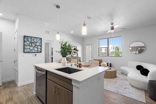 A modern kitchen with a large island and a living area with a sofa.