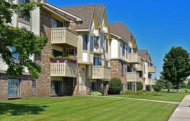 an apartment building on a sunny day with a grassy area in front of it