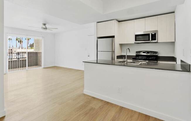 A kitchen with a refrigerator, stove, and microwave.