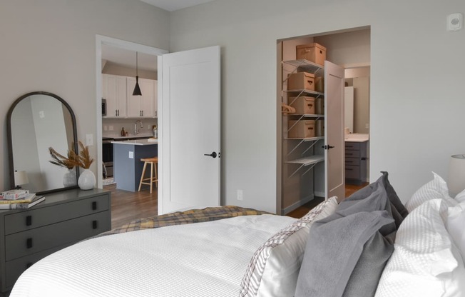 a bedroom with a bed and a closet and a kitchen