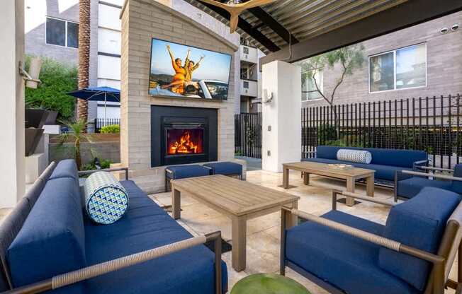 A patio with a fireplace and a television displaying a person jumping.