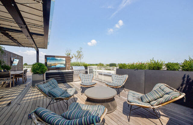 a patio with chairs and a table and a tv
