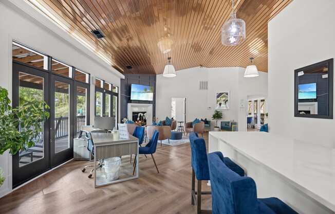 a living room with blue chairs and a bar and a fireplace