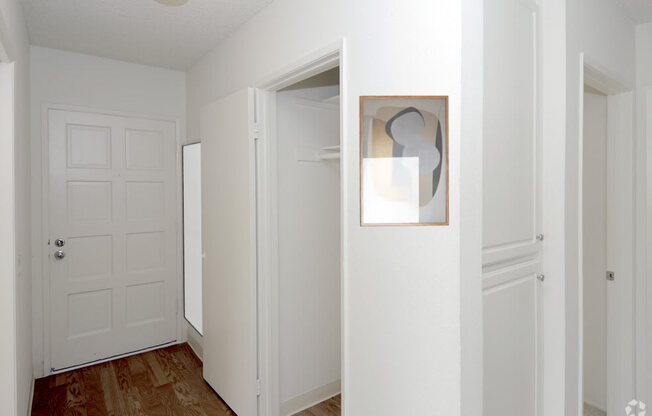 a bedroom with a white door and a painting on the wall