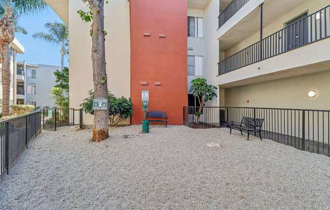A courtyard with a red wall and a tree in the middle.