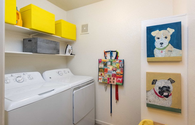 a laundry room with a washing machine and a painting of a dog