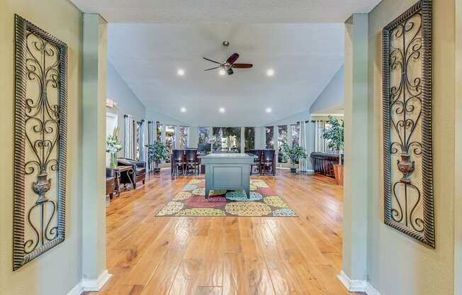 a large living room with a table and a ceiling fan