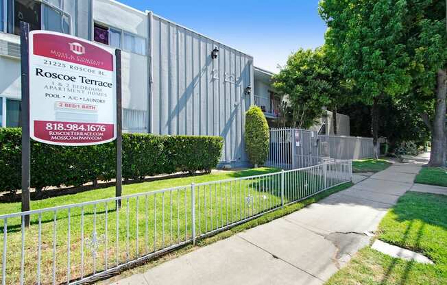 a fence in front of a building with a sign on it