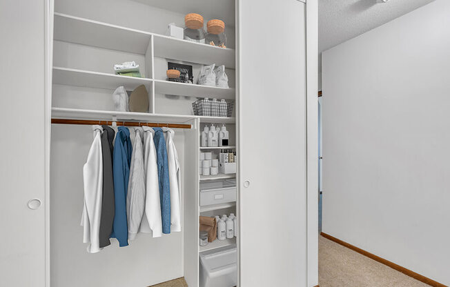 a walk in closet with shelves and clothes