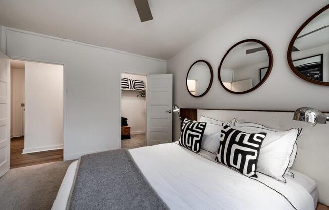 a bedroom with a bed and mirrors on the wall