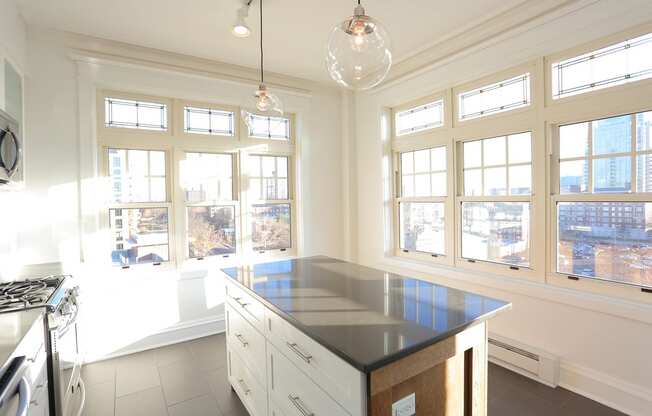 Kitchen with slate tile flooring, island, pendant lights and large corner windows. at York House, Saint Louis, MO, 63108