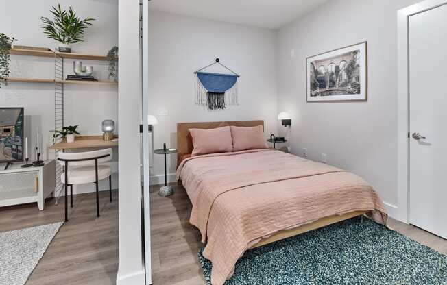 Chic bedroom area in a studio apartment at The Mint Rahway, featuring a comfortable bed, workspace, and stylish decor.