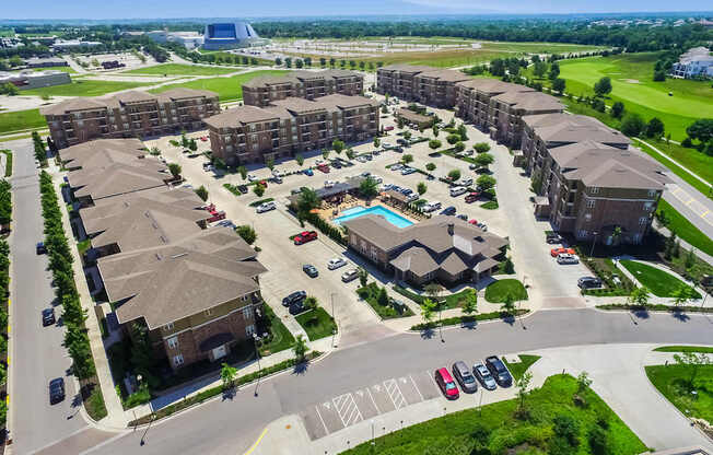 A large apartment complex with a pool in the middle of the courtyard.